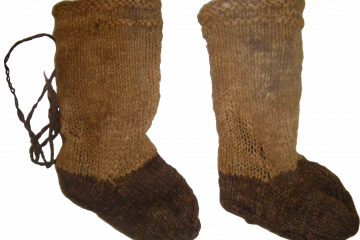 Пара старинных вязаных носков коричневых оттенков на нейтральном фоне.