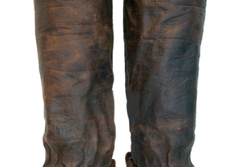 Пара высоких кожаных сапог тёмного цвета.